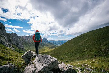 Successful woman hiker climbing up on high altitude mountain top