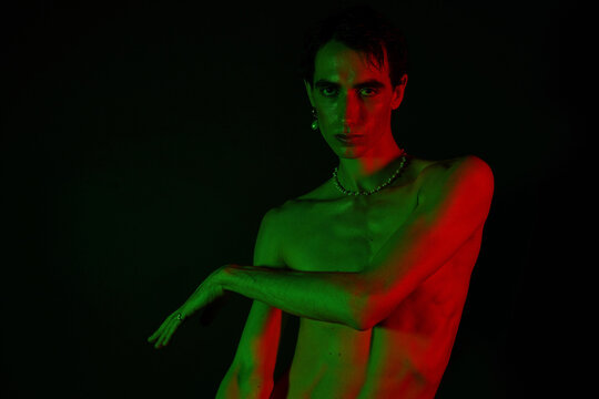 Stylish man posed in dramatic lighting showcasing modern fashion and artistic expression