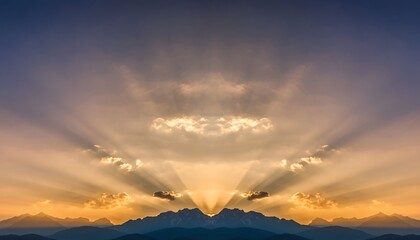 Dramatic sunset over mountains with shining rays of light and cloudy sky