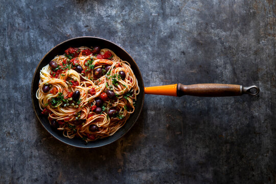 Spaghetti pasta in skillet. cooked spaghetti with tomato oilves capers