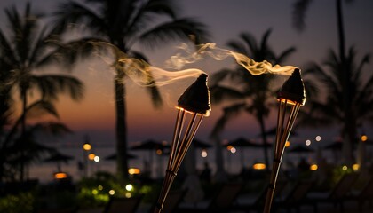Evening scene of tiki torches with smoke and palm trees at dusk
