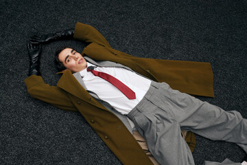 Stylish man resting on the floor, showcasing a unique fashion statement in an artistic setting