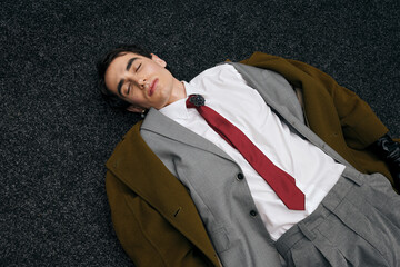 Handsome stylish man resting on carpet in a modern indoor setting during daytime
