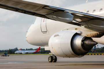 Traffic at airport on sunny day. Close-up view taxiing passenger airplane to runway for take off.