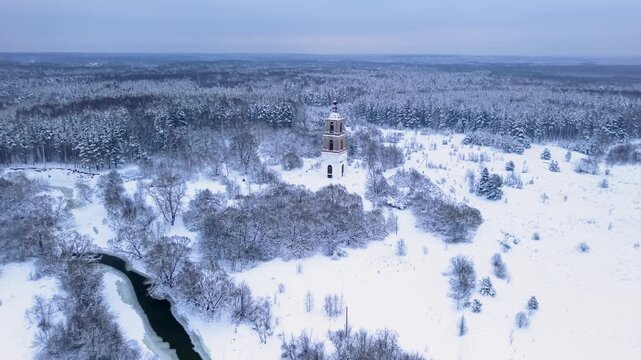 Drone ascends above historic bell tower revealing vast snowy forest horizon, delivering cinematic winter scenery for travel marketing, storytelling, and branding projects
