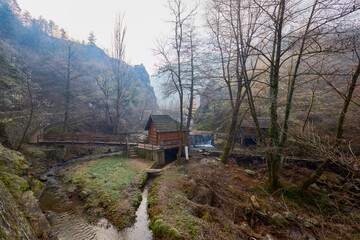 Landscape of the Almaj Valley in Romania, with the watermills of Rudăria and the mountain river.