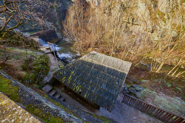 Landscape of the Almaj Valley in Romania, with the watermills of Rudăria and the mountain river.