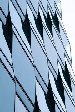 Corporate modern office building architecture featuring abstract facade geometry pattern in glass with clean professional future business concept