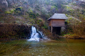 Landscape of the Almaj Valley in Romania, with the watermills of Rudăria and the mountain river.