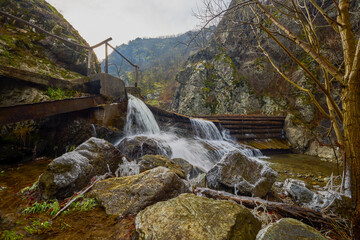 Landscape of the Almaj Valley in Romania, with the watermills of Rudăria and the mountain river.