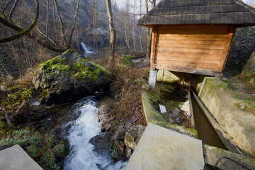 Landscape of the Almaj Valley in Romania, with the watermills of Rudăria and the mountain river.