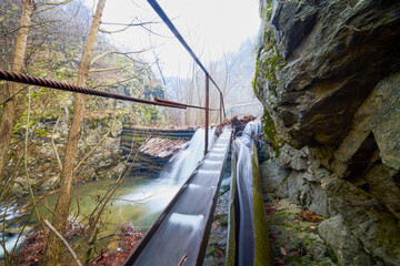 Landscape of the Almaj Valley in Romania, with the watermills of Rudăria and the mountain river.
