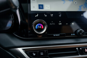 Fototapeta premium A premium, modern brown car interior, leather steering wheel, large navigation screen, air ducts, deflectors on the car panel. Interior details.