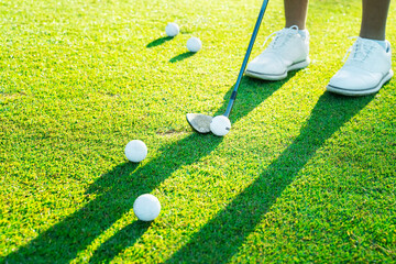 Golf practice at a luxury course in bright sunshine with multiple golf balls around