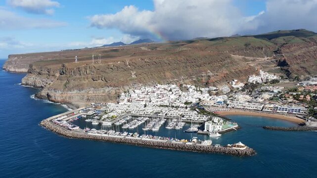 Puerto de Mog&aacute;n Aerial View with Rainbow over the South Coast of Gran Canaria, Canary Islands - 4K Cinematic Shot