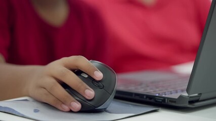 Close-up of student s hand on a wireless computer mouse, working on a laptop during a STEM coding session or online learning activity. - Powered by Adobe