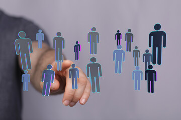 Hand pointing at a collection of digital human icons, symbolizing connection, teamwork, and global network. Ide