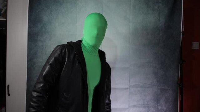 Man in a black jacket posing for a portrait on green screen.