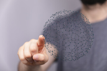 Close-up of a finger touching a sphere representing a digital network or interconnected technology...