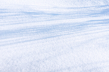 sparkling snow field with long shadows in winter sun