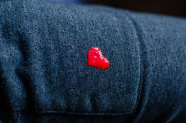A small red heart painted on gray pants