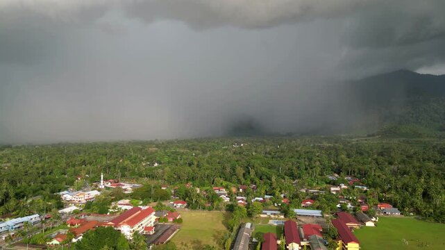 A cloudy sky with a mountain in the background. The sky is dark and the clouds are thick. Aerial view Yan, Kedah
