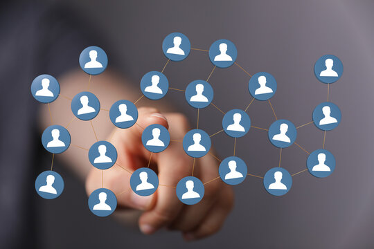 Hand pointing at a network of user icons, symbolizing connection, teamwork, and global communication. - Powered by Adobe