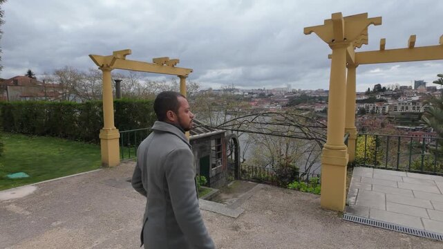 Man looking at city view from scenic viewpoint
Person observing the city from a viewpoint framed by traditional architecture elements.