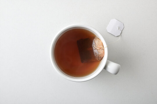 Tea bag in white ceramic mug isolated in the center