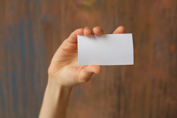 Obraz premium Hand Holding Blank Card Over Wooden Background for Mockup, Presentation, Note, Template, Stock Photography
