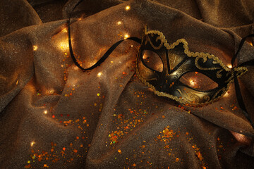 Venetian mask with gold decorations on a shiny background