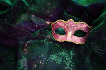 Venetian mask with gold decorations on a shiny background