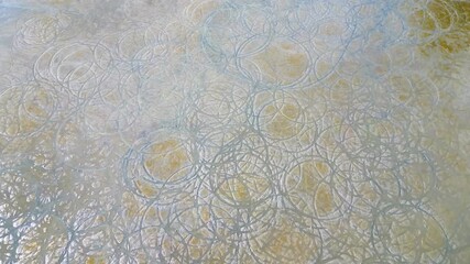 A wall with a pattern of circles. The circles are white and the wall is tan. The circles are very close together