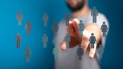 Abstract conceptual image of a hand selecting a person icon from a group, representing choices and...