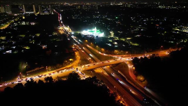 A city street with a large intersection. There are many cars on the road. The street lights are on. Aerial night view Larkin