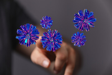 Digitally rendered abstract spheres in blue and pink light near a finger, representing digital connection and