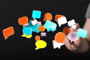 Hand reaching towards a network of colorful speech bubbles, representing communication and social...