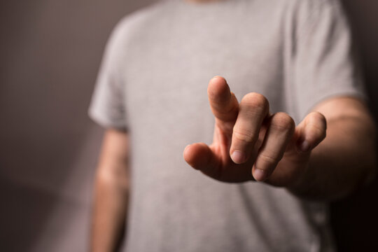 A man's hand pointing directly at the camera. Represents touch, connection, and the act of pointing or selecting - Powered by Adobe