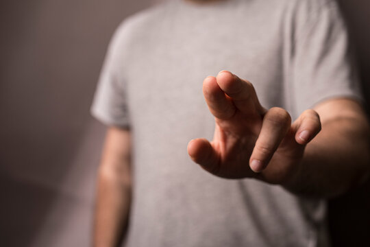 Close-up of a man's hand extending forward. The image showcases the detail of the skin and the gesture, evoking
