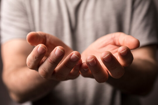 Close-up shot of cupped hands outstretched, depicting concepts of giving, receiving, support, hope, and compassi