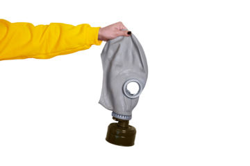 Close-up of a hand in a yellow sleeve holding a gray gas mask on transparent background, symbolizing safety, protection, and emergency preparedness.