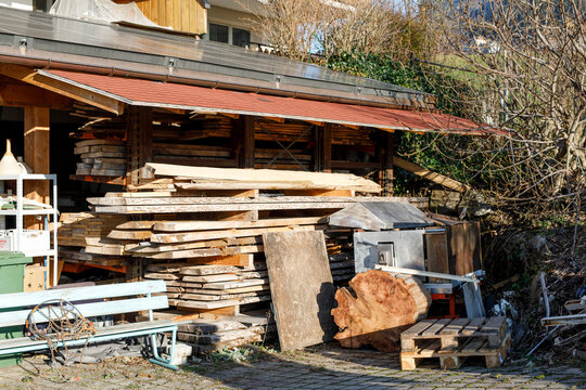 Stack of timber planks in an old sawmill shed. Building materials, wood storage, carpentry work, lum