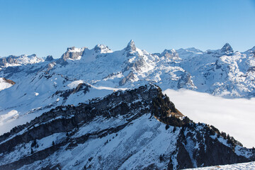Panoramic view of snow-covered mountain range under a clear blue sky, capturing the beauty of nature