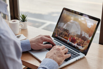 live concert streaming online, video streaming concert, man watching live music clip on internet on laptop in cafe