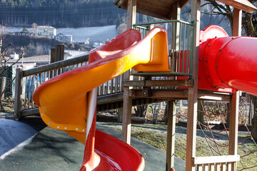 Fun playground slide with mountain background. Perfect for childhood, outdoor, and recreation themes