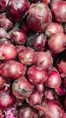 Top view of fresh organic red onions pile. Natural texture of purple vegetable skins for food background