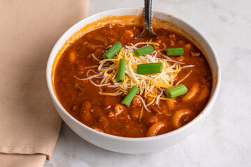 chilli macaroni  top with  green onions and cheese