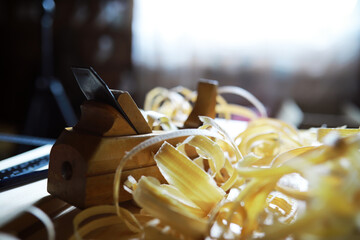 Plane jointer carpenter or joiner tool and wood shavings. Woodworking tools on wooden table. Carpentry workshop