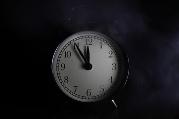 Vintage Alarm Clock with Smoky Background in Low Light Setting