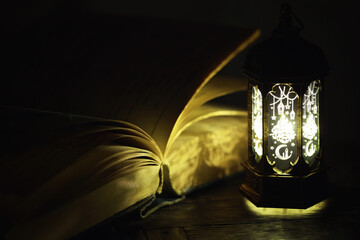 Ornamental Arabic lantern with burning candle glowing at night. Festive greeting card, invitation for Muslim holy month Ramadan Kareem.
